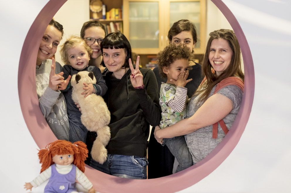 Gruppenfoto mehrerer Familien mit kleinen Kindern auf der Familienetage des Familienzentrums – ein Ort der Begegnung, Gemeinschaft und frühkindlichen Förderung.