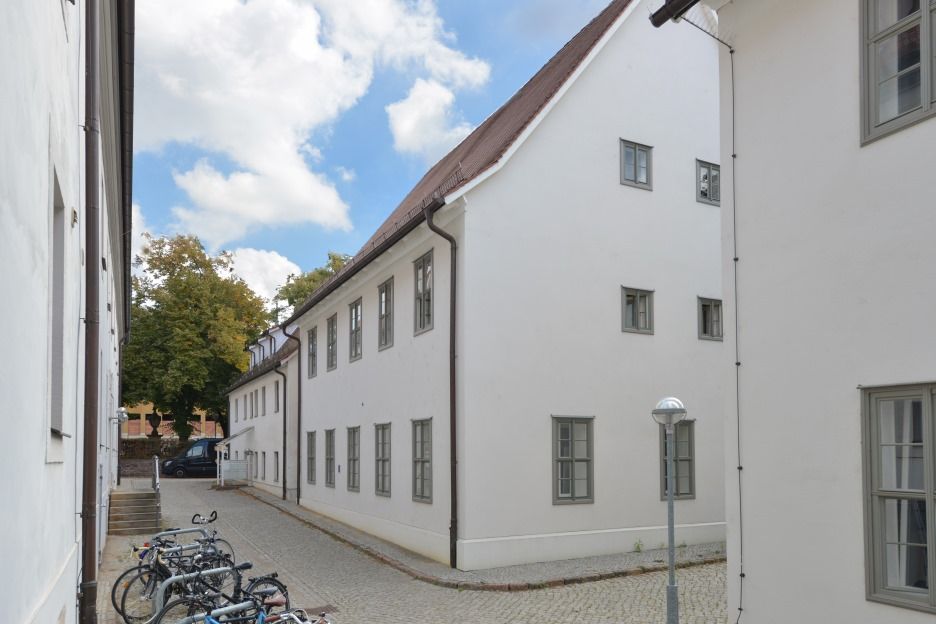 Blick von Westen in die Stiftungsgasse südlich des Schwarzen Weges mit den historischen Wirtschaftsgebäuden, unter anderem dem Gebäude mit Tierställen. 