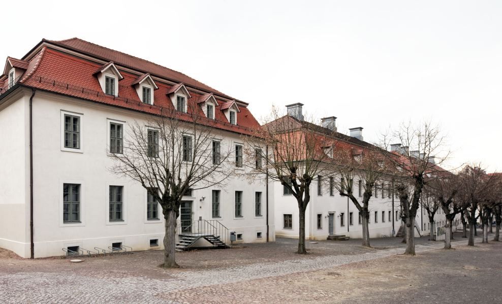 Ansicht der Häuser auf der Südseite des Lindenhofs mit zwei Geschossen und Walmdach. 