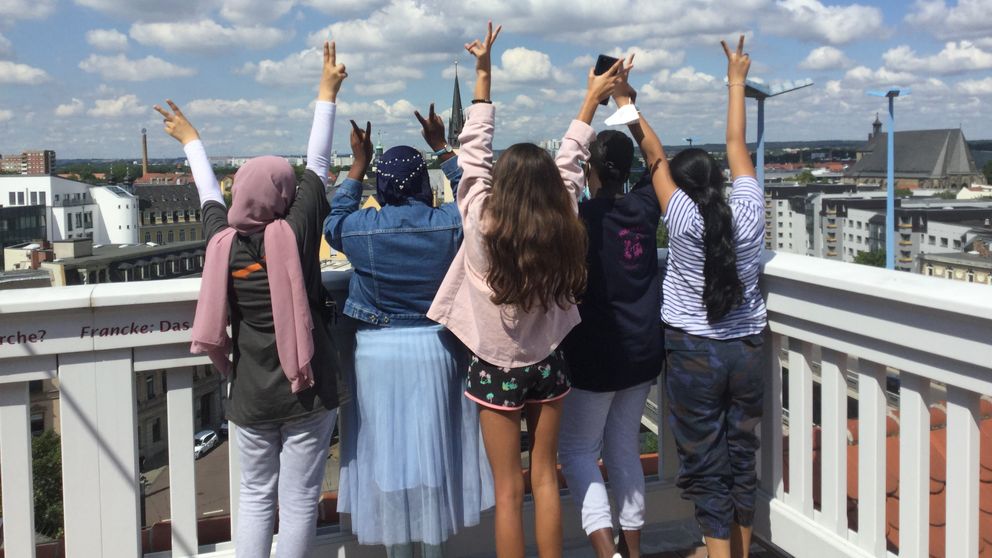 Mehrere Kinder stehen auf dem Altan des Historischen Waisenhauses und zeigen gespannt in den Himmel.