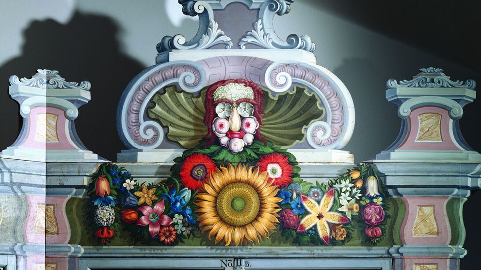Detailaufnahme eines kunstvoll arrangierten Blumengesichts als Bekrönung eines historischen Pflanzenschranks aus der Kunst- und Naturalienkammer, inspiriert von Giuseppe Arcimboldo.