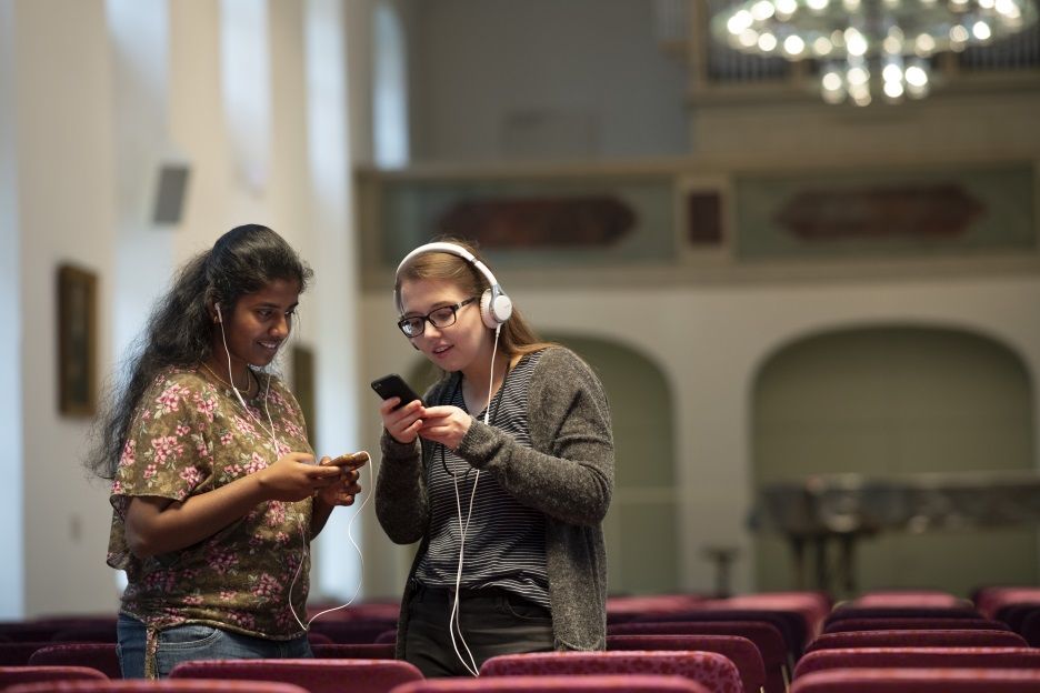Zwei Besucherinnen hören sich im Freylinghausen-Saal per Audioguide Informationen zur Geschichte und Ausstattung des Raumes an. 