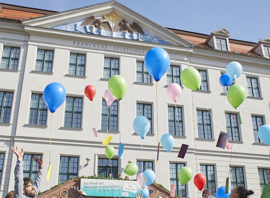 Vor der Fassade des Historischen Waisenhauses steigen bunte Luftballons mit Zeichnungen und Wünschen der Kinder des Krokoseums in den Himmel auf